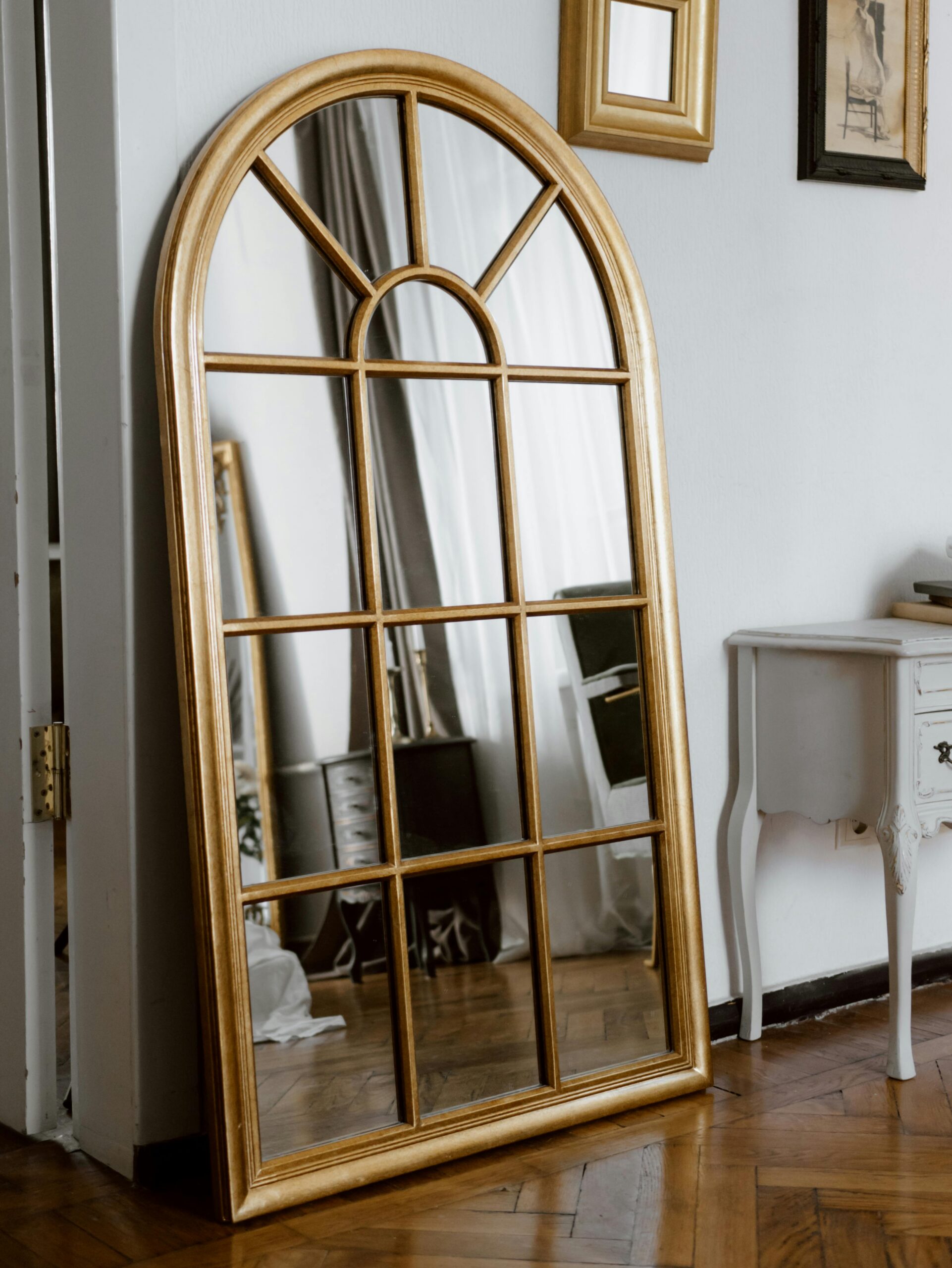 Arched wooden framed mirror on the wall