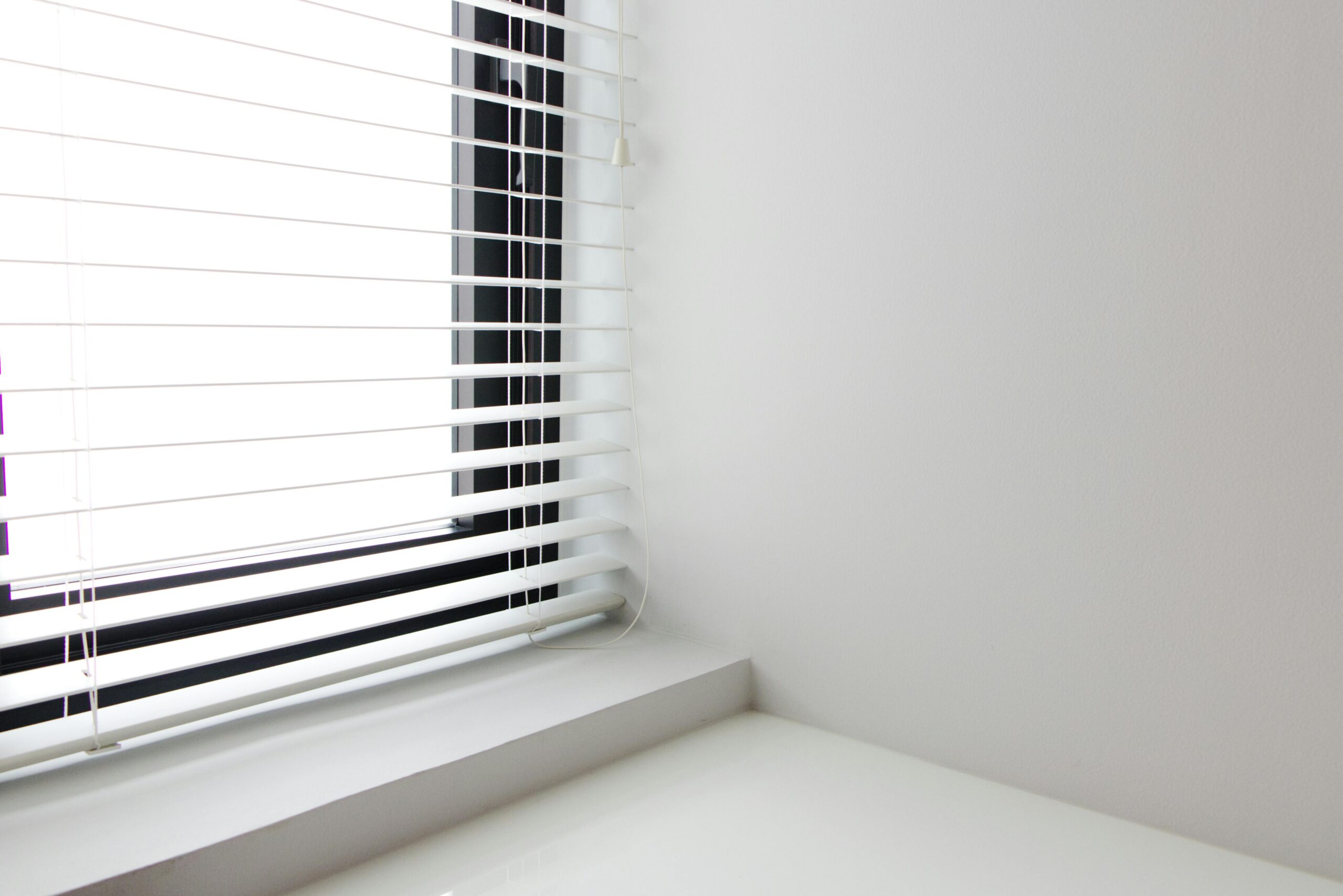 White window blinds on white wall